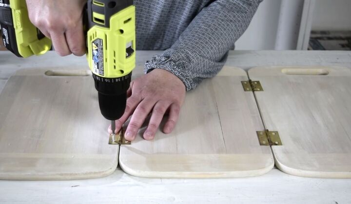 a person using a drill to attach wooden boards