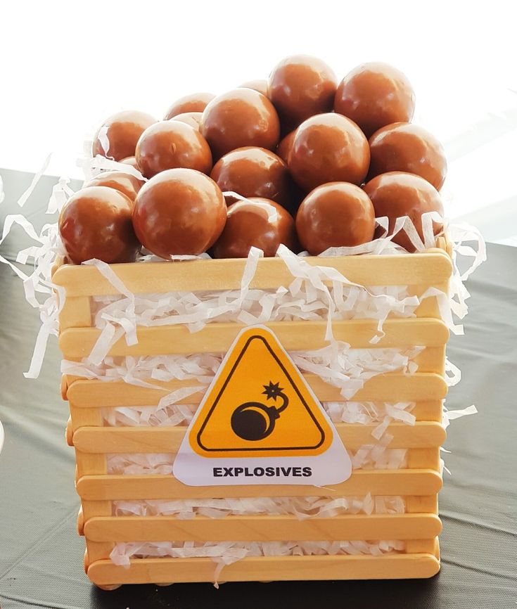 a wooden crate filled with chocolate donuts on top of a table