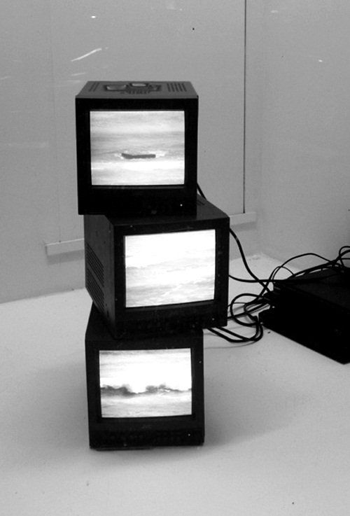 three televisions sitting on top of each other in front of a white wall and floor