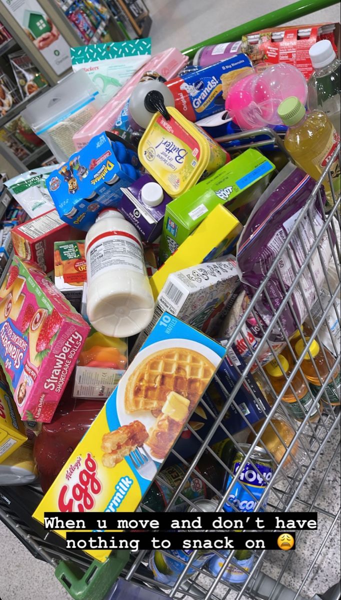 a shopping cart filled with lots of food next to a pile of milk and yogurt