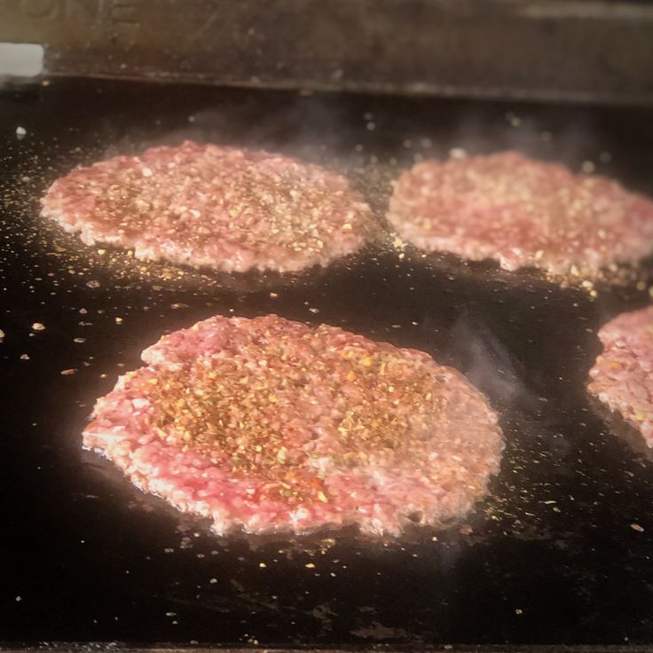 hamburger patties being cooked on an outdoor grill