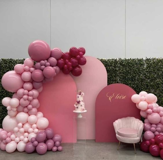 balloons and chairs are set up in front of a backdrop