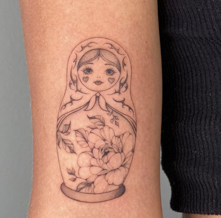 a woman's leg with a tattoo on it that has flowers in a vase