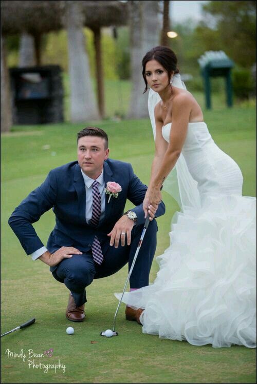 a man kneeling down next to a woman in a wedding dress holding a golf club