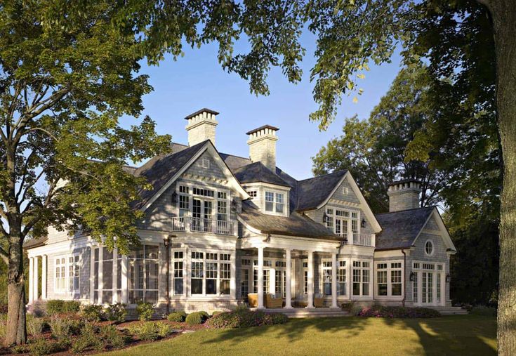 a large white house surrounded by trees and grass