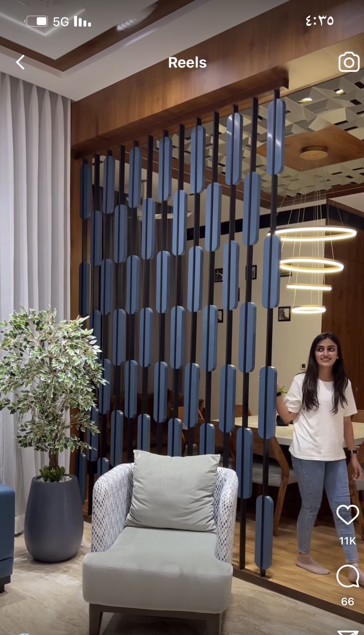 a woman standing in front of a living room with blue and white decor on the walls