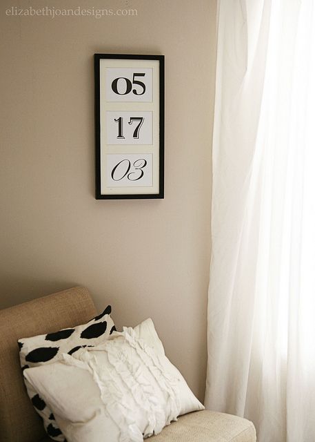 a chair sitting in front of a window next to a white curtain and clock on the wall