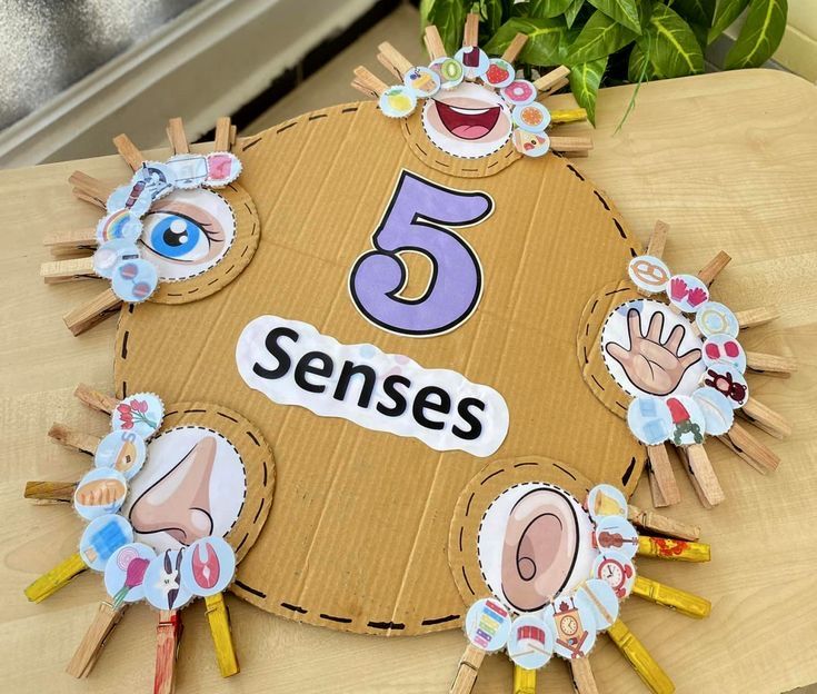 a cardboard sign with stickers on it that says 5 sense and has five fingers in the center