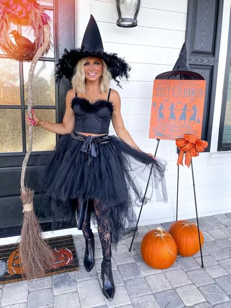 a woman dressed up as a witch holding a broom