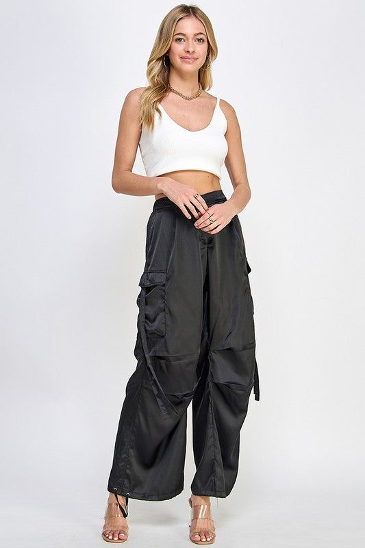 These daily-style cargo pants are made from quality satin fabric and have a relaxed fit. A high-waist design and adjustable side leg allow you to create a custom look and feel. Deep side pockets provide storage and a zipper and elastic waistband ensure a secure fit. Perfect for casual and everyday style. Fabric & fit: Model is wearing size Small. Utility Cargo Pants, Style Cargo, Pants Large, Daily Style, Everyday Style, Black Satin, Daily Fashion, Satin Fabric, Cargo Pants