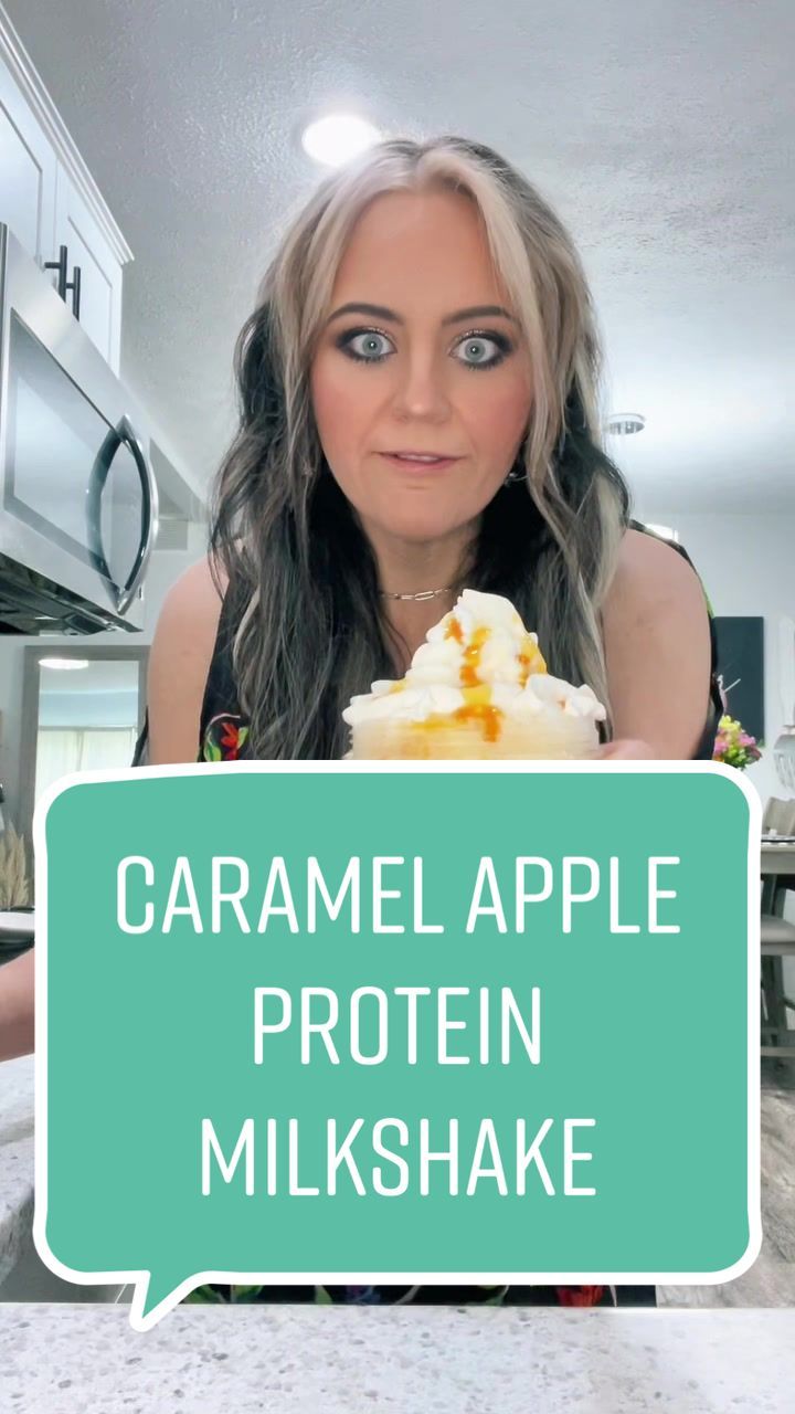 a woman holding up a piece of cake with the words caramel apple protein milkshake