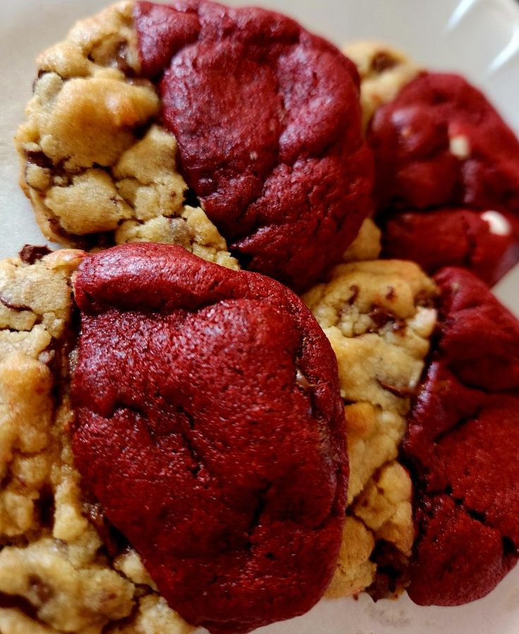 three cookies with red fillings are on a plate