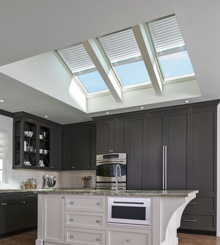 a kitchen with an island and skylights above it