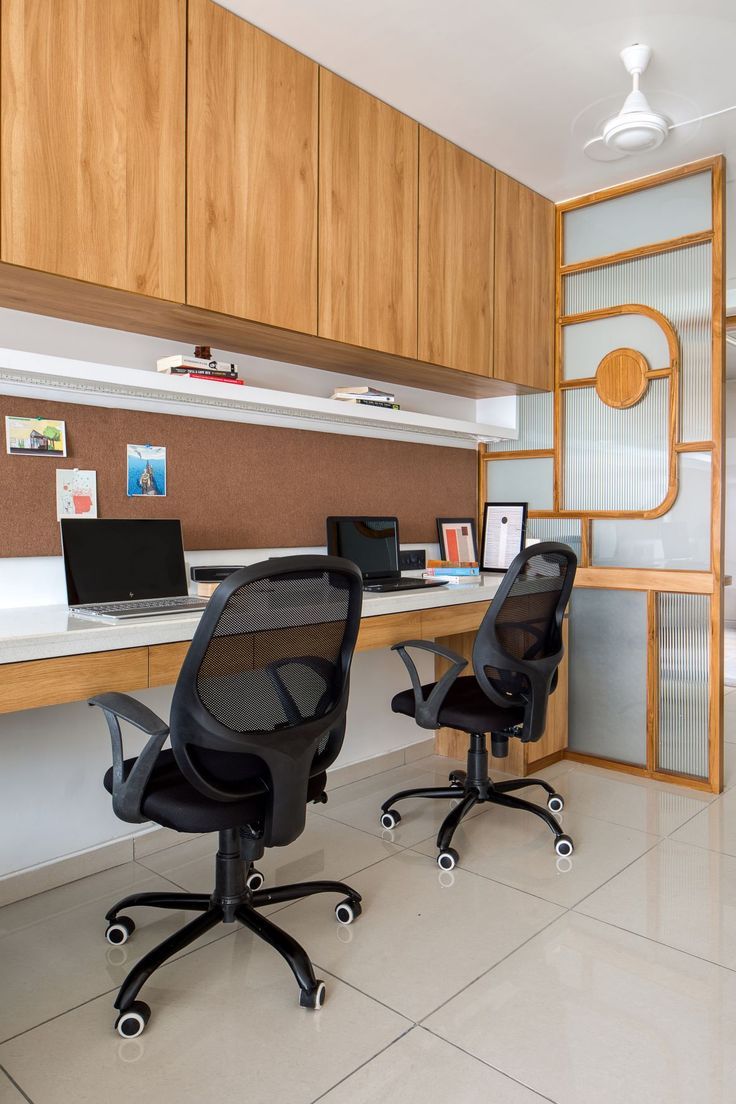 two office chairs sitting in front of a desk