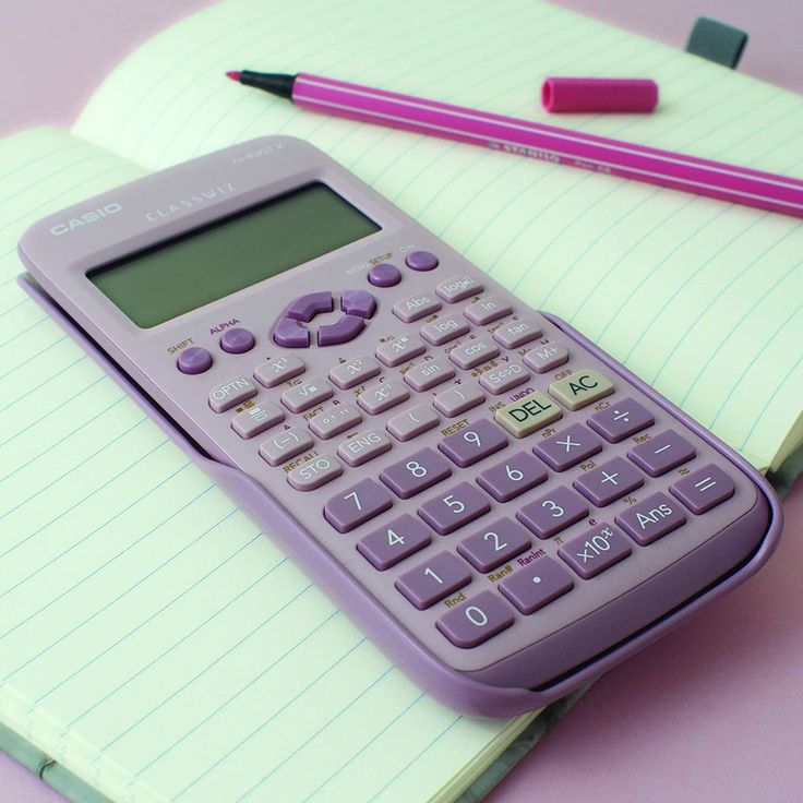 a purple calculator sitting on top of a notepad next to a pencil