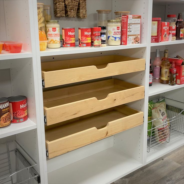 an organized pantry with lots of food in bins and baskets on the bottom shelf