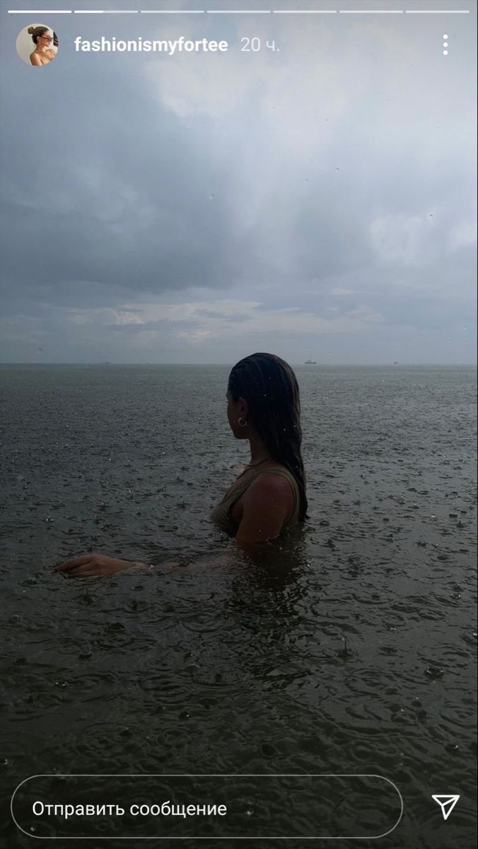 a woman is sitting in the water with her back turned