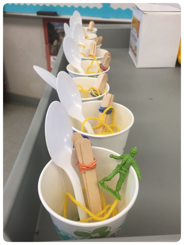 plastic cups with spoons and forks are lined up