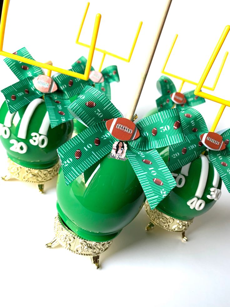 two green football themed vases with bows on them