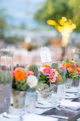 there are many vases with flowers in them on the table at this wedding reception