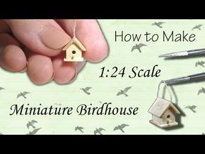 the miniature birdhouse is being held by someone's hand