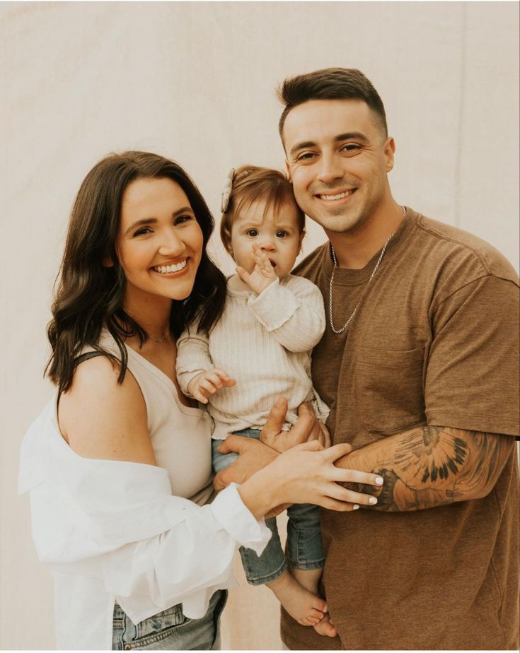 a man, woman and child posing for a photo with their arms around each other