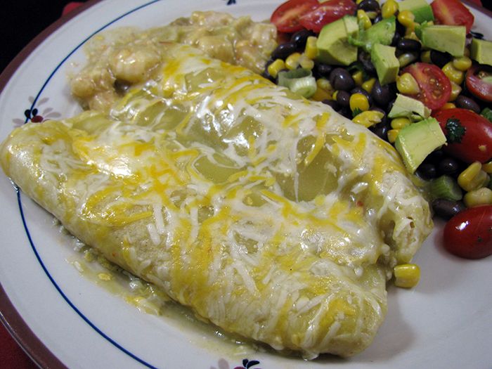 an enchilada and salad are on a plate