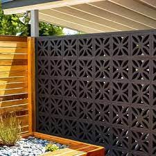 a wooden box with plants in it next to a fence and some rocks on the ground