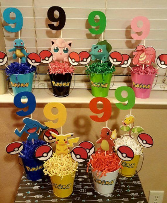 a table topped with cupcakes covered in candy next to numbers and cups filled with candies