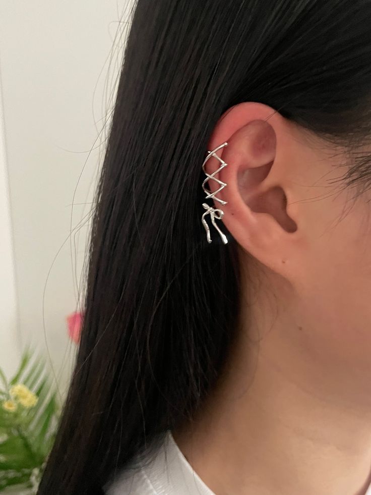 Unleash your daring side with Shoshana's ballet-core-inspired ear cuff! Featuring a lace-up design with a ribbon dangle and a mini pink cubic stone, this feminine yet edgy accessory will add a trendy touch to any outfit. Embrace the challenge and elevate your style with Shoshana.This ear cuff is meticulously crafted from nickel-free plated brass, ensuring both style and comfort. It's designed to be worn without a piercing hole-simply slide it onto your conch, snug, or helix area by gently opening the hoop. Please be mindful not to exert excessive force while adjusting to maintain the jewelry's shape and integrity.-Nickel-free plated brass-Type A: Short lace-up ear cuff with pink stone ribbon-Type A Earcuff: 13mm(dia)*9.6mm-Type A Ribbon: 15*22.5mm-Type B: Long lace-up ear cuff with an atta Side Piercing Ear, Earring Stacks Small Ears, Attached Earlobe Piercings, Ear Piercings Edgy, Piercings Ear Aesthetic, Feminine Piercings, Side Ear Piercing, Ribbon Piercing, Cute Ear Cuffs