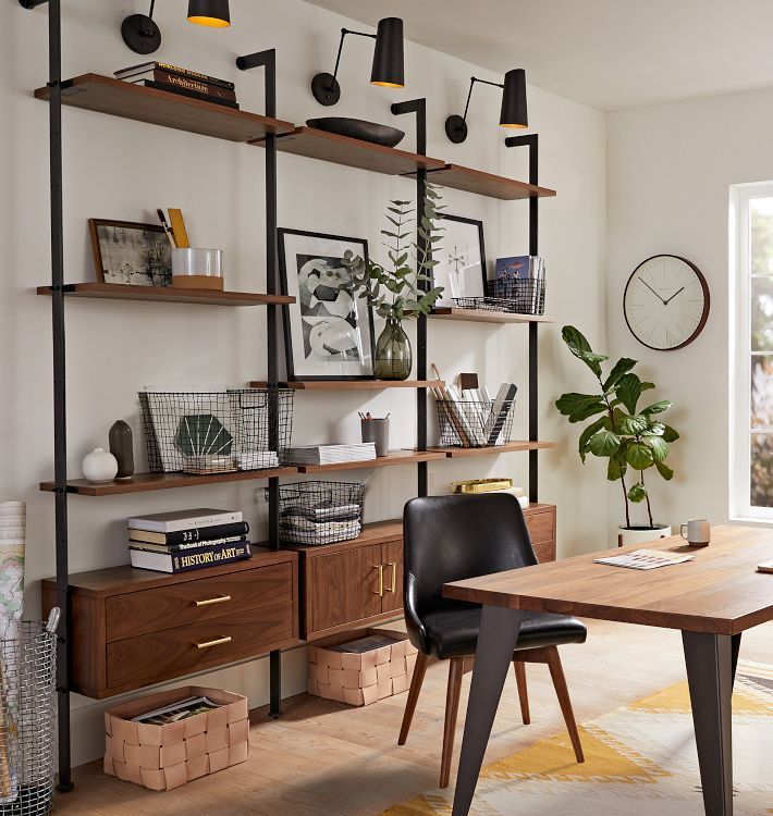 a room with a wooden table and shelves on the wall next to a large window