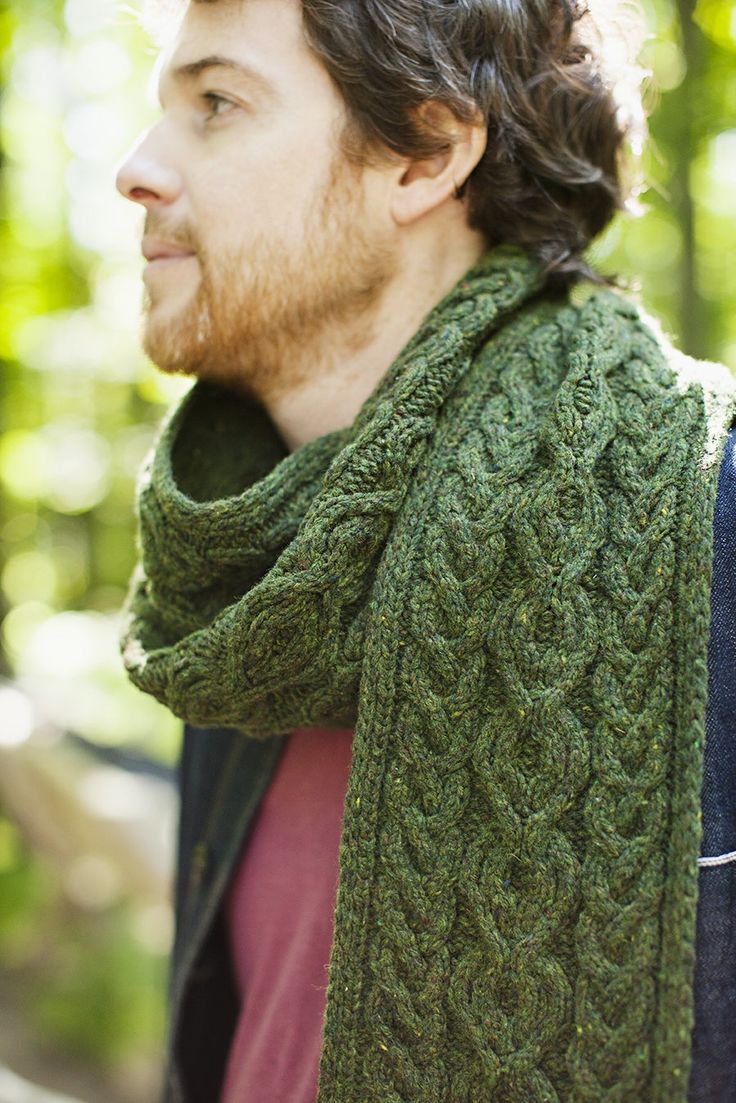 a man wearing a green knitted scarf