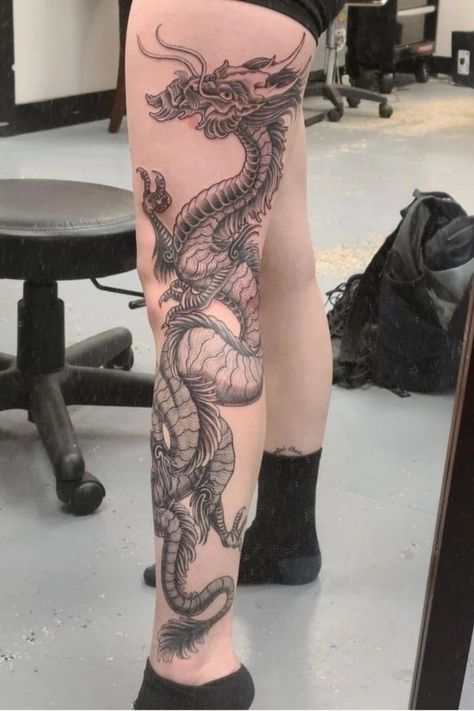 a woman's leg with a dragon tattoo on it