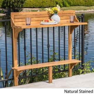 a wooden bench sitting on top of a metal fence next to a body of water