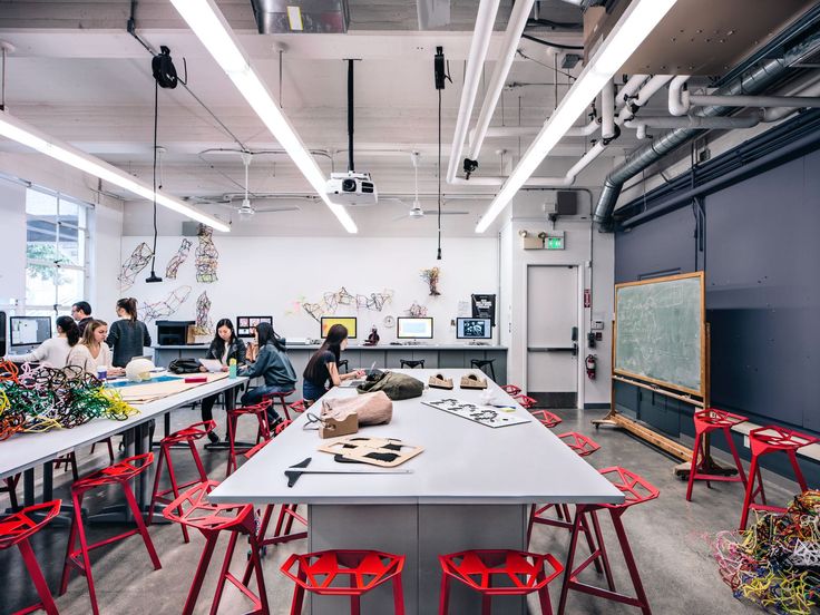 an empty classroom with red chairs and desks