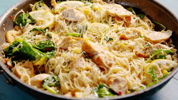 a pan filled with pasta and vegetables on top of a table