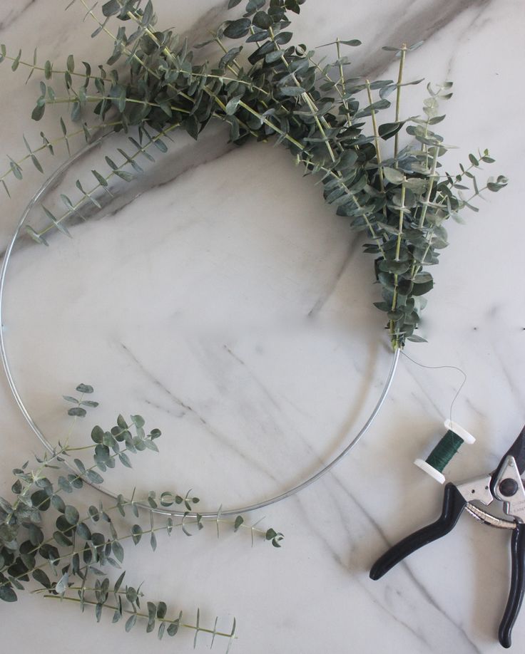 scissors and greenery on a marble table