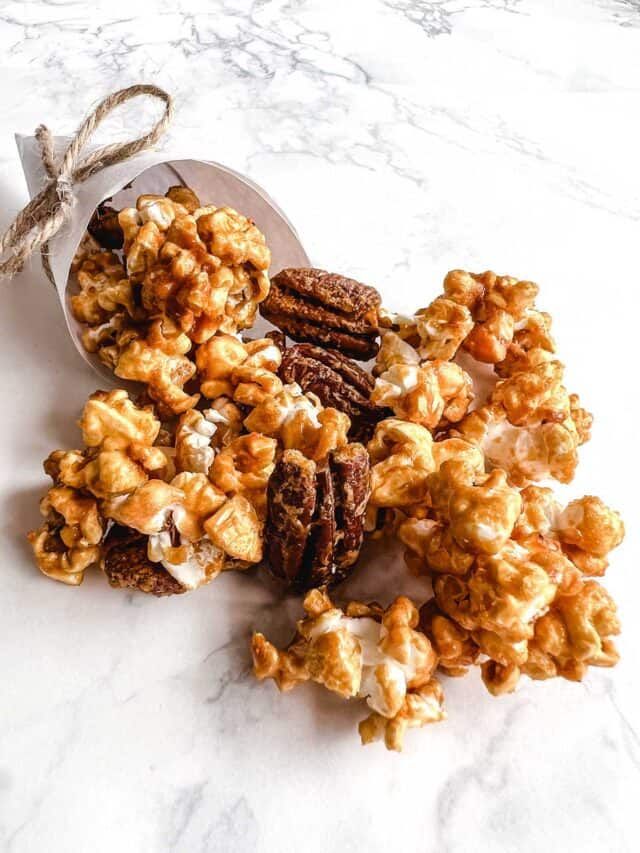 there is a spoon full of caramel popcorn on top of the table with words above it