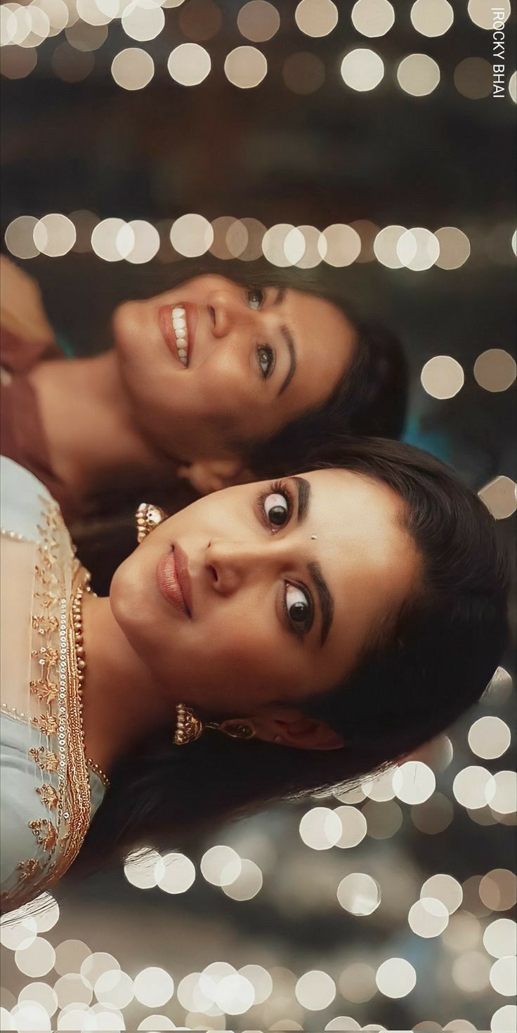 two women are laying down in front of some lights