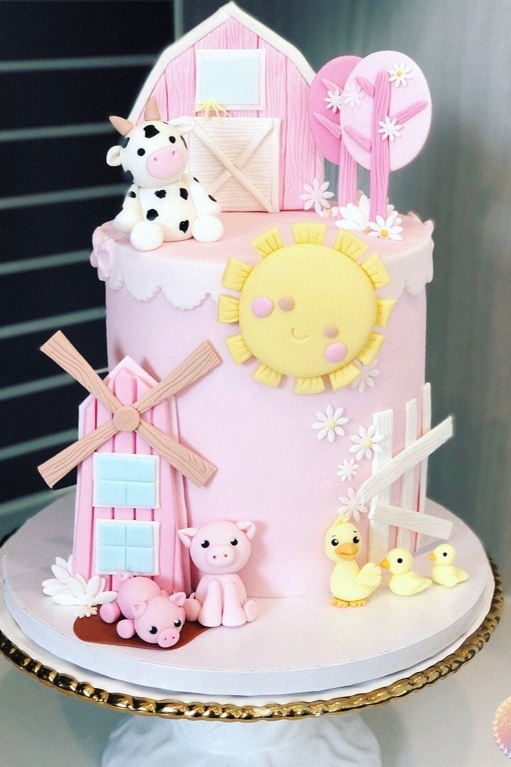 a pink cake with farm animals on it