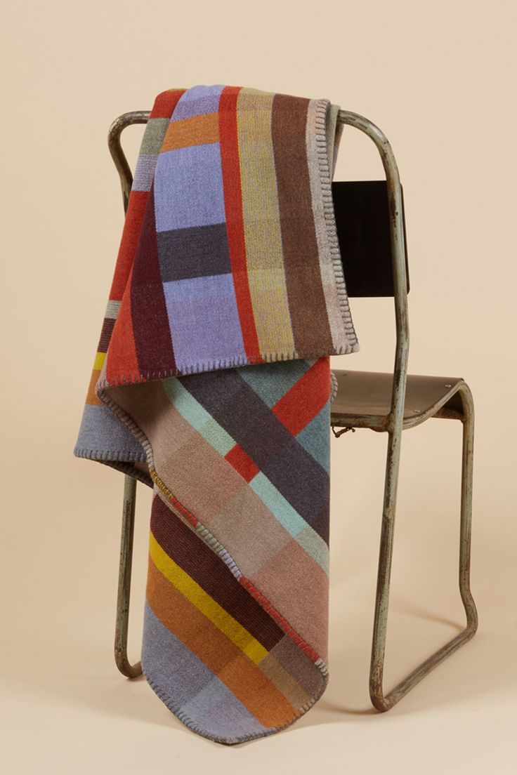 a multicolored blanket sitting on top of a metal chair