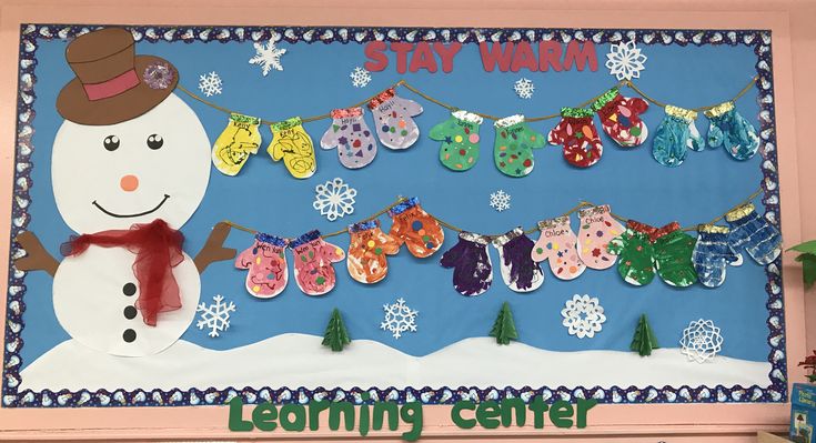 a bulletin board with snowman and clothes hanging from it's sides in the classroom