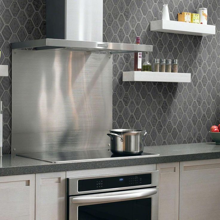 a stove top oven sitting inside of a kitchen next to a wall mounted shelf filled with pots and pans