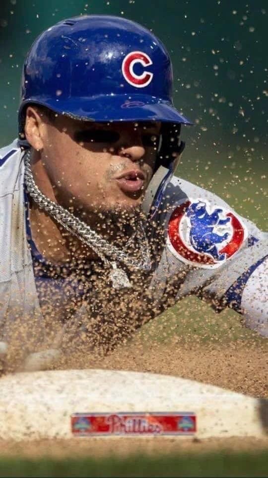 a baseball player sliding into home plate during a game in the dirt and water splashing on his face