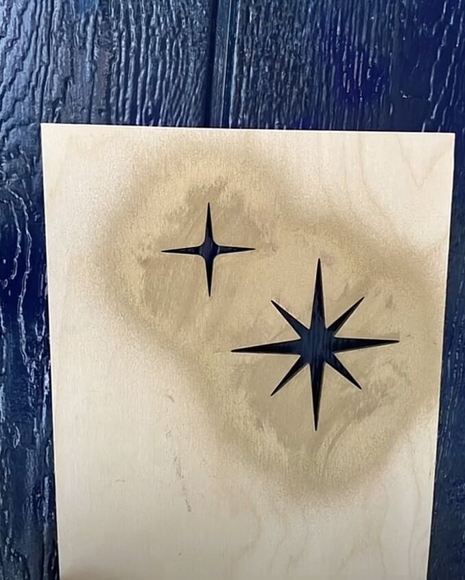 two black stars are on a white piece of wood