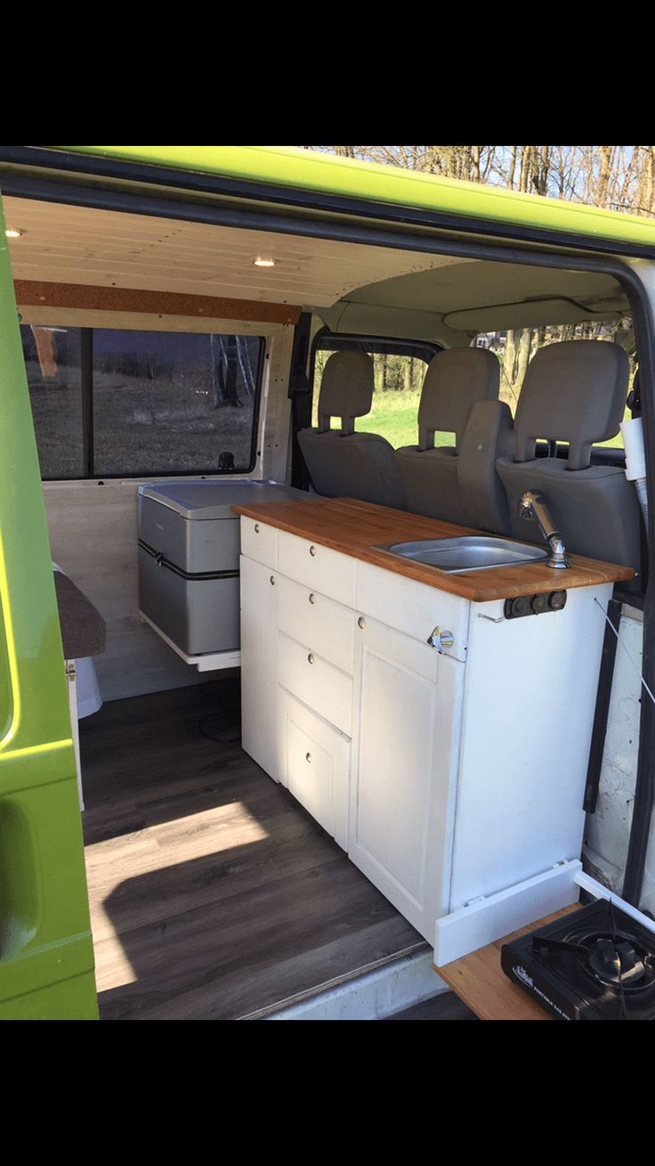 the interior of a van with an oven and sink in it's back door