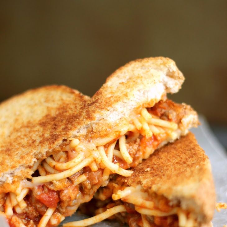 a grilled cheese and tomato sandwich is on a plate, with the rest of the sandwich cut in half