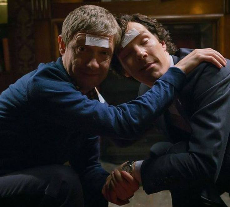 two men with bandages on their foreheads hugging each other