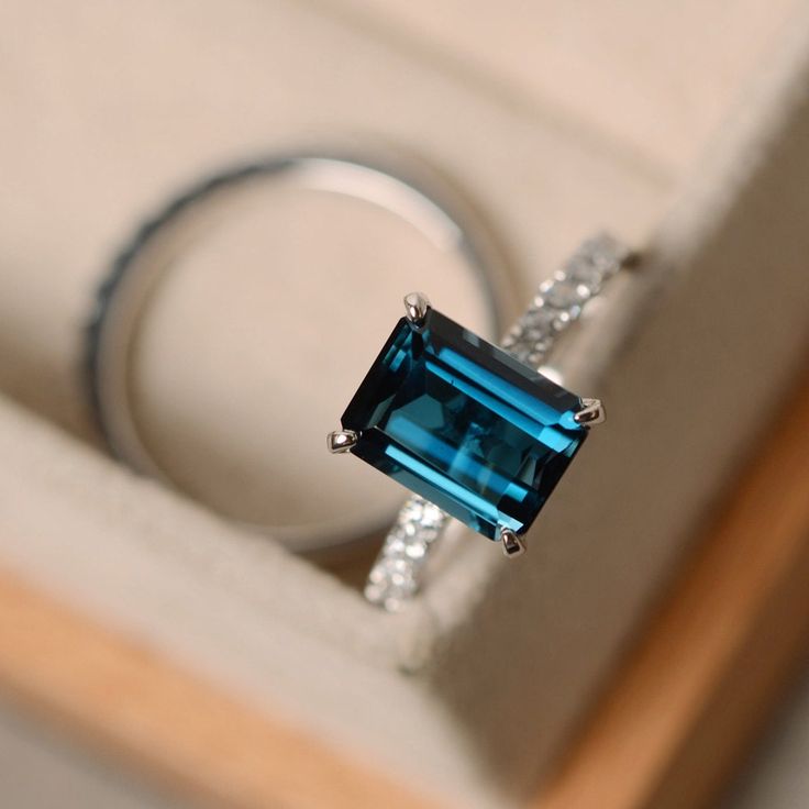 This ring features a 7*9mm emerald cut London blue topaz and sterling silver finished with rhodium. Customization is available. It is made by hand, and it will take about 7 days to finish the ring after your payment is completed. Main stone: London blue topaz London blue topaz weight: Approx 3.15 ct Metal type: sterling silver finished with rhodium Accent stone: cz Customization is available, I also can make it with 14k solid gold (white or yellow or rose) and diamond accent stone, just feel fre London Blue Topaz Engagement Rings, November Birthstone Ring, Blue Topaz Engagement Ring, Topaz Engagement Ring, London Blue Topaz Ring, Engagement Ring Cuts, Ring Blue, November Birthstone, Silver Engagement Rings