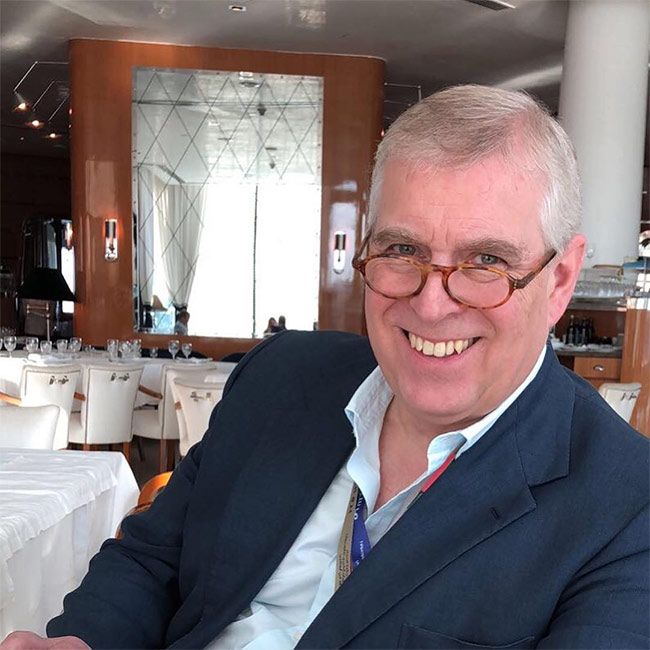 a man sitting at a table in a restaurant with white tables and chairs behind him